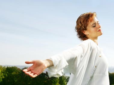 Woman standing with arms stretched out feeling no fear due to hypnosis for phobias